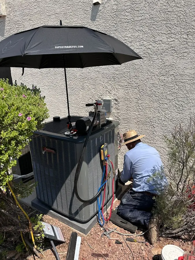 HVAC technician performing outdoor AC maintenance in Belle Plaine